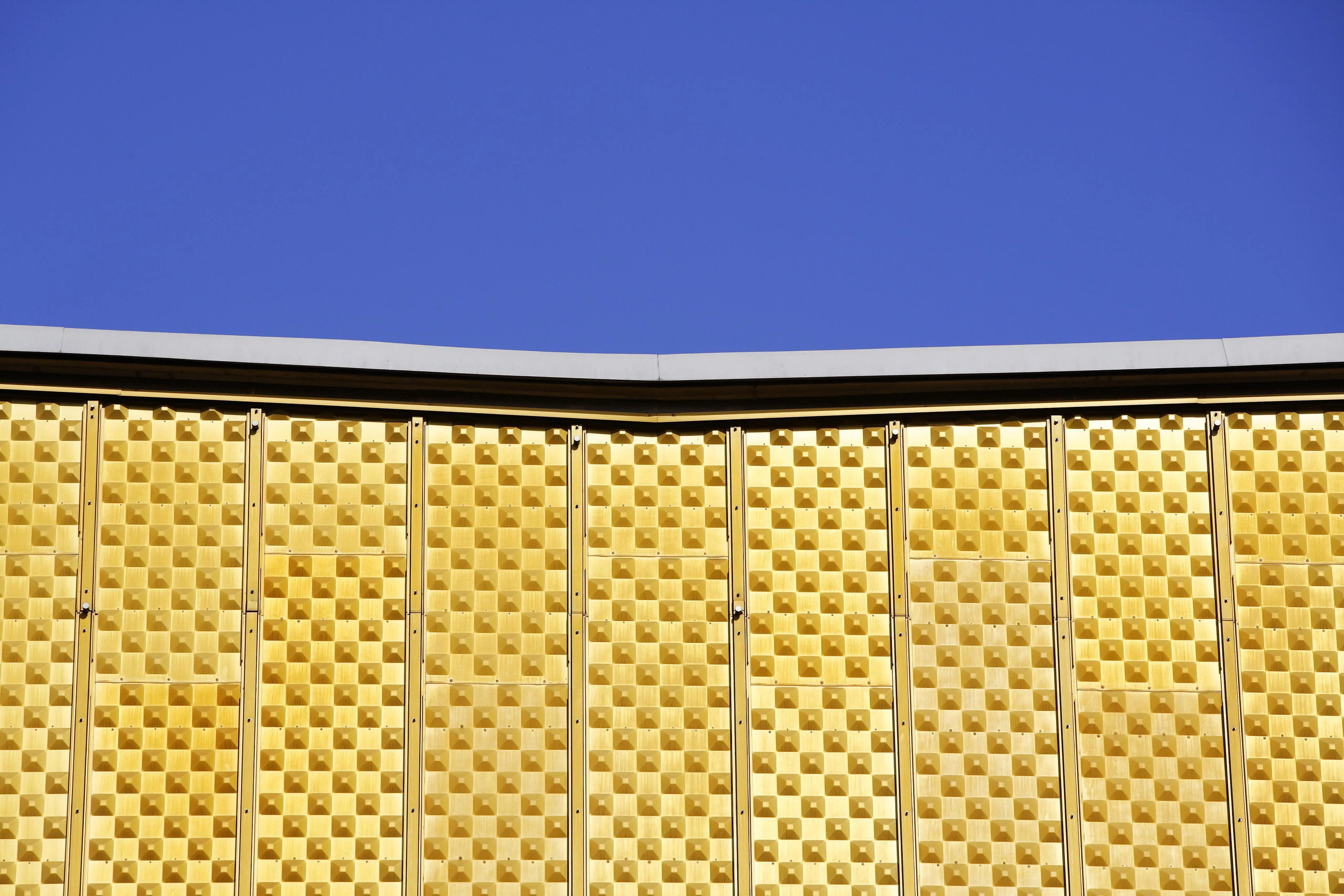 Blauer Himmel über der gelben Fassade der Philharmonie in Berlin